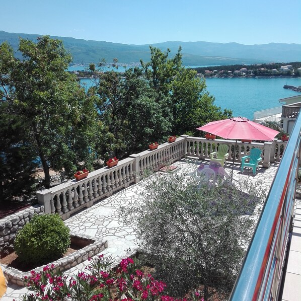 Enjoy the serene view of the water and distant mountains from this balcony.