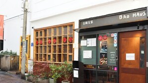 A restaurant with a wooden facade, a sign reading "BAO HAU", and a window displaying food items. - Avani Central Busan (Busan)