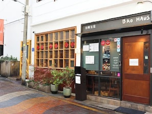 A restaurant with a wooden facade, a sign reading "BAO HAU", and a window displaying food items. - Avani Central Busan (Busan)