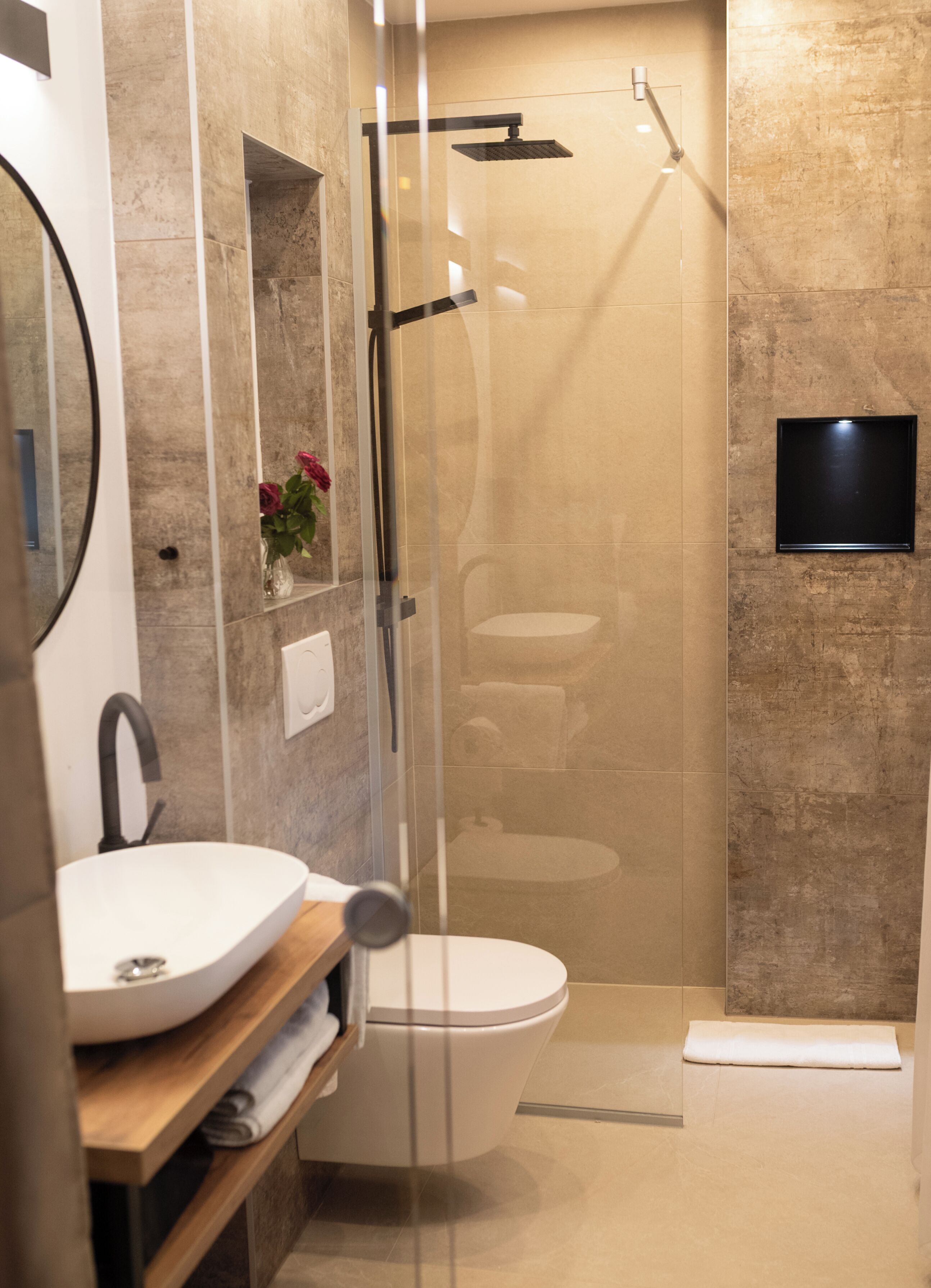 Une salle de bain moderne avec une douche à parois de verre, un lavabo blanc et des toilettes.