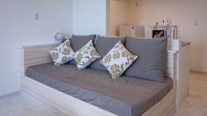 Un dormitorio moderno con cama, ropa de cama gris y almohadones decorativos.