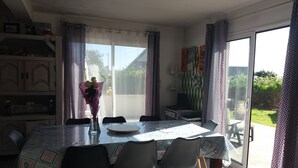 Un coin repas avec une table, des chaises et un vase de fleurs.