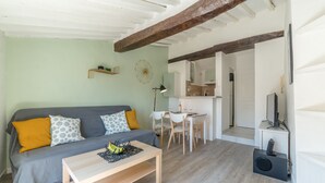 Ein gemütliches Wohnzimmer mit einer Couch, einem Couchtisch und einem Essbereich.