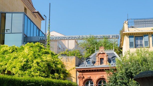 Ein Gebäude mit moderner Glasfassade und traditioneller Architektur mit aufwendigen Details.