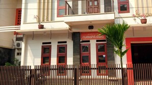 A two-story building with a flat roof, a balcony on the upper floor, and a sign indicating it is a guest house. - Rumah Tawa Guesthouse 1 (Bandung)