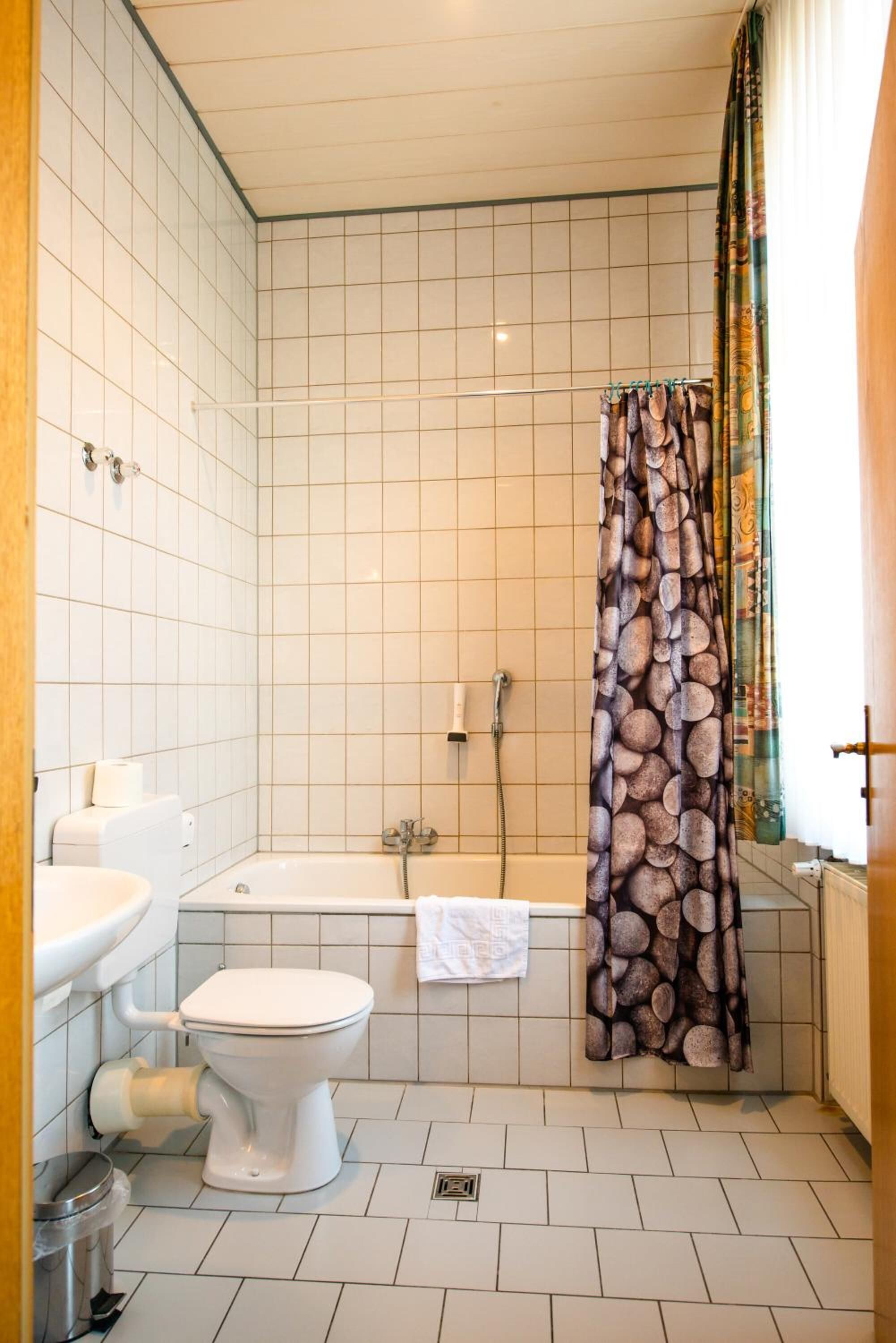 Kylpyhuone, jossa on wc, pesuallas ja kylpyamme.