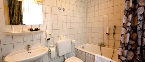 Un baño con lavamanos, inodoro y bañera.