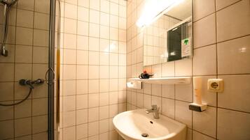 A bathroom with a shower, sink, and mirror.