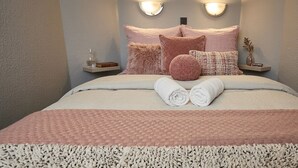 A neatly made bed with rolled towels, a textured pink blanket, and a fluffy white throw. - F2 luxury air-conditioned sea view 100 meters from the beach in the famous Marina. (Villeneuve-Loubet)