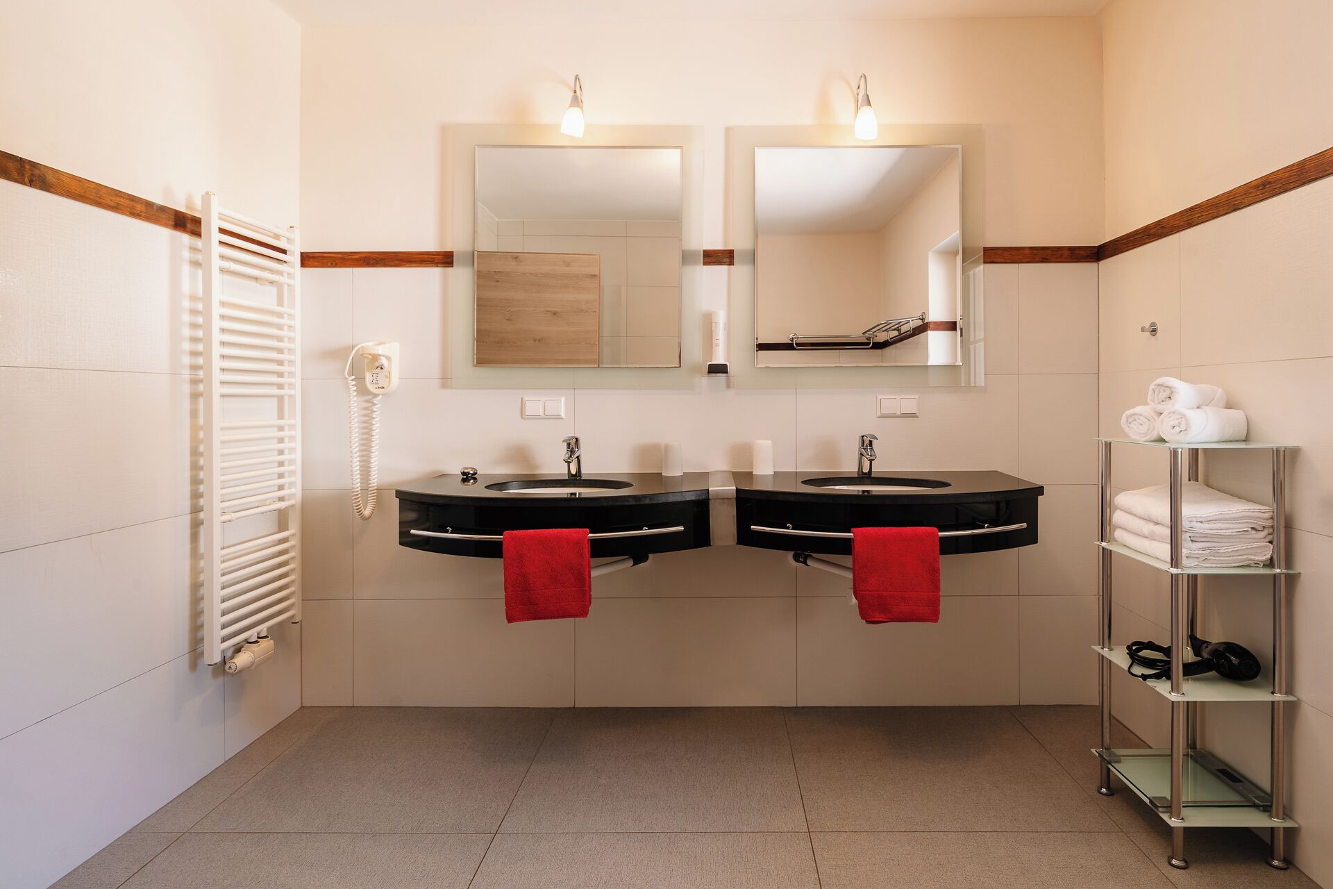 Un bagno con due lavabi, uno specchio, un telefono e un portasciugamani.