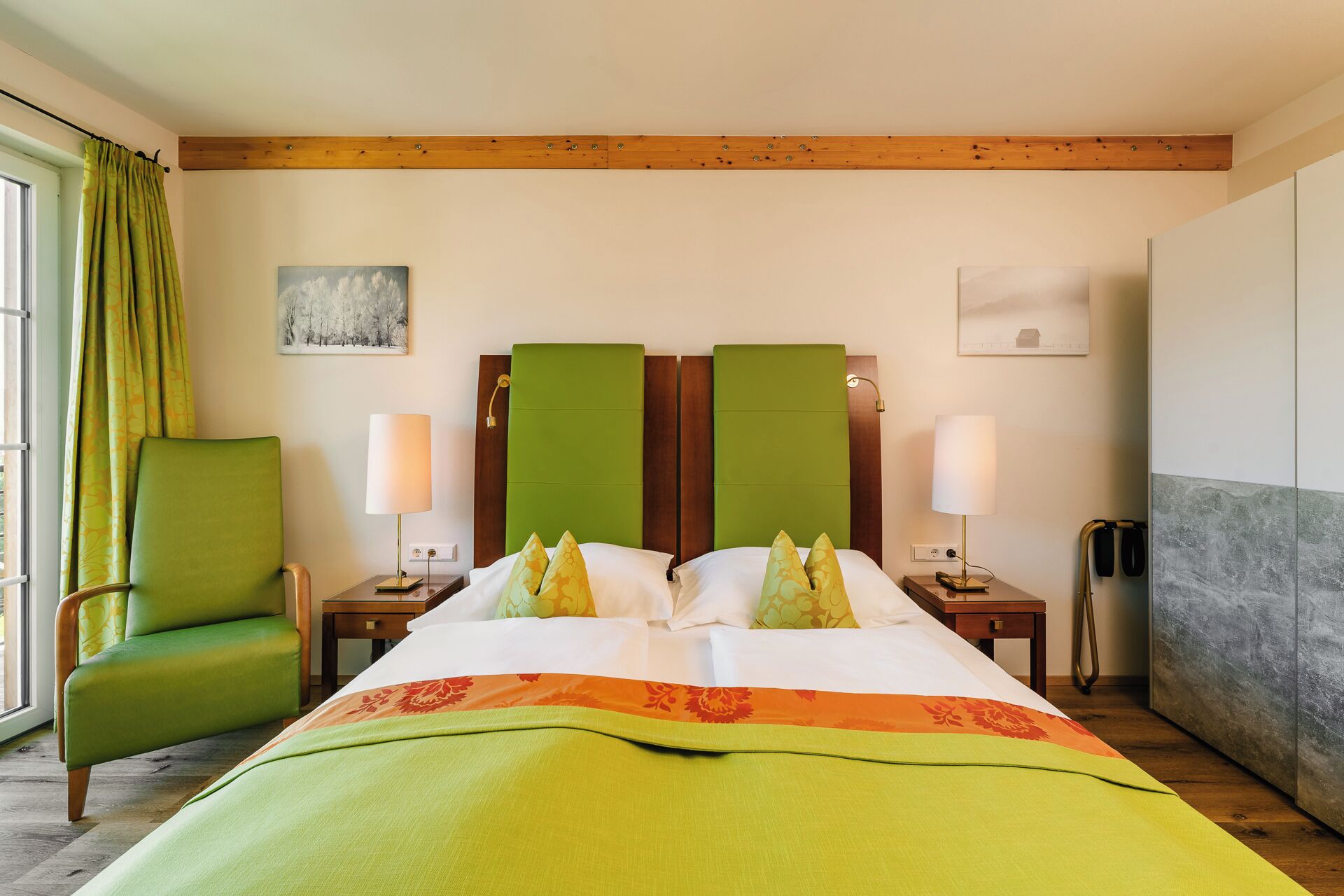 A hotel room with a bed, two bedside tables, a chair, and a painting on the wall.