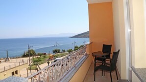 A balcony with a view of the sea, a table, and two chairs. - B&B Mimì (Castelsardo)