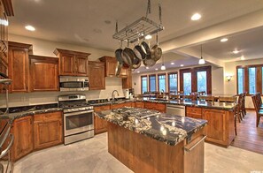 Enjoy cooking in this well-equipped kitchen with a large island, stainless steel appliances, and ample cabinetry.