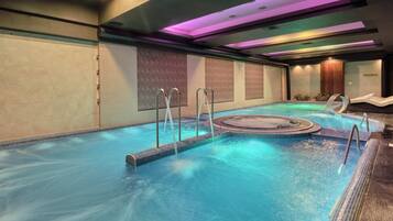Una piscina techada, una piscina al aire libre de temporada, sombrillas