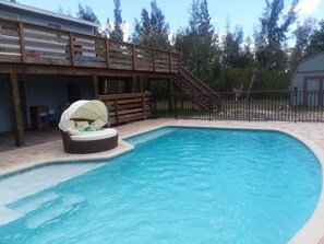 A swimming pool with a wooden deck and a lounge chair. - Fish, Swim, Boat, Kayak, Snorkel, Bike, Hike,  Dolphin Watch and Island Hopping. (St James City)