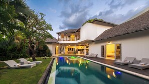 Uma casa moderna com piscina, varanda e um jardim bem cuidado.