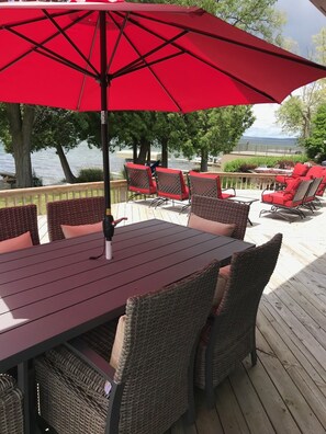 A deck with a table and chairs, overlooking a body of water. - Waterfront Vacation Home Directly on Hubbard Lake - East Shore (Spruce)