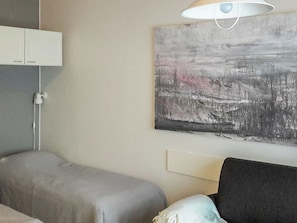 A bedroom with a bed, bedside table, and a wall-mounted lamp. - Kanerva 202 by Interhome (Äkäslompolo)