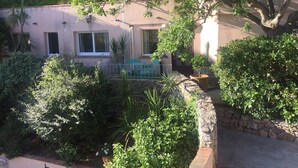 A house with a patio area, a small garden, and a stone wall. - Three star studio (Sète)