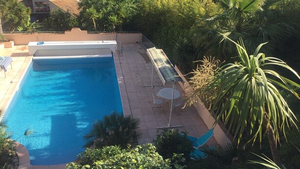 A swimming pool with a view of a cityscape and mountains in the background. - Three star studio (Sète)