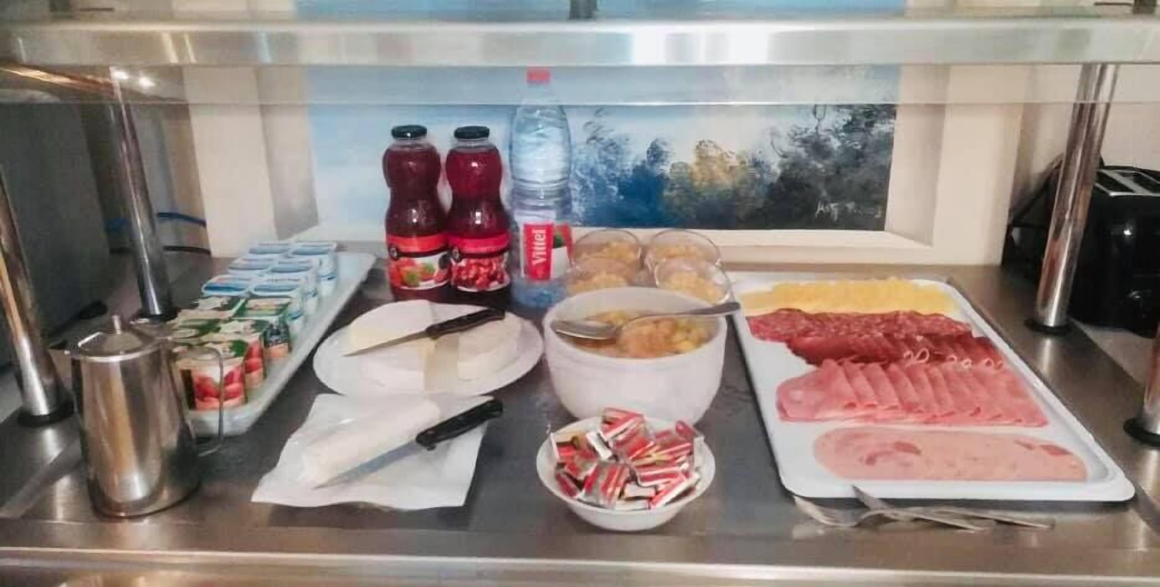 Un buffet con diverse pietanze, condimenti e utensili.