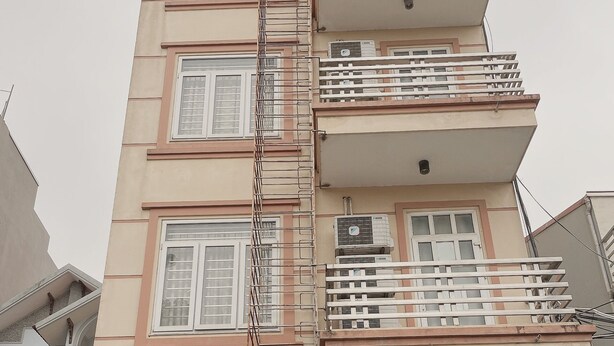 Un hotel llamado 'Titanic Hotel' con una fachada moderna, varios balcones y un llamativo cartel de 'Bienvenido' en la entrada.