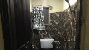 Een badkamer met toilet, bidet en douche.