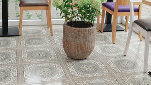 A cozy indoor seating area with a patterned floor, wooden chairs, and a large potted plant. - Heilotel (Heilbad Heiligenstadt)