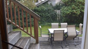 A patio with a wooden staircase leading to a covered outdoor area.