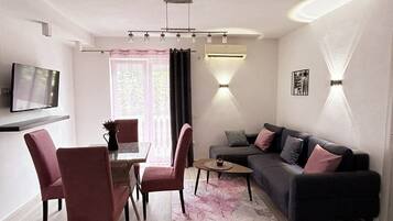 Familienapartment, Stadtblick (Purple) | Wohnbereich | 32-Zoll-Flachbildfernseher mit Satellitenempfang, Fernseher