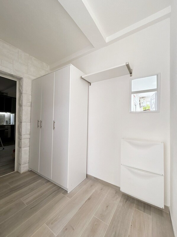 A room with a large wardrobe, a small window, and a radiator.
