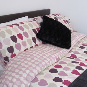 A bed with a patterned bedspread and pillows. - Spacious Flat Fenham (Newcastle-upon-Tyne)