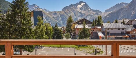 A mountain town with a parking lot, buildings, and a mountain backdrop.