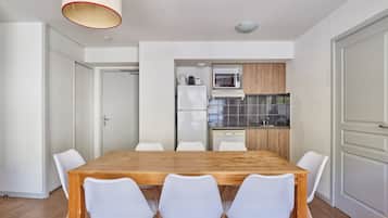 A modern kitchen with white cabinets, a microwave, and a refrigerator.
