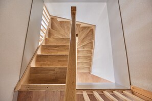Un escalier en bois, doté d’une rampe, mène à un niveau supérieur.