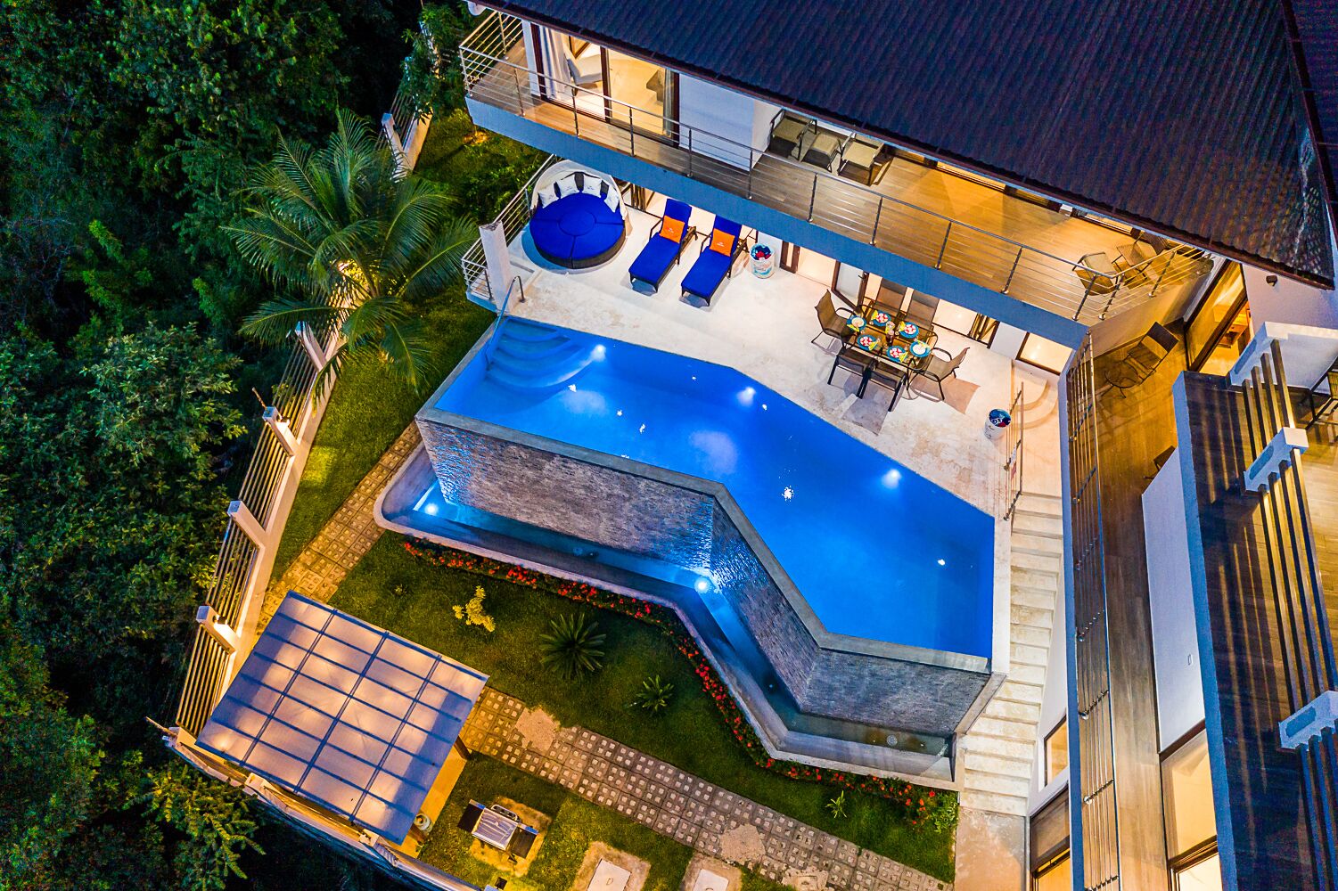A modern house with a swimming pool, outdoor seating, and a well-maintained garden.