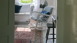 A room with a window, a sofa, a chair, a small table, and a rug. - “STEP BACK IN TIME” 1880’ charmer.<br>Riverside Cottage<br> entire house (Warren)