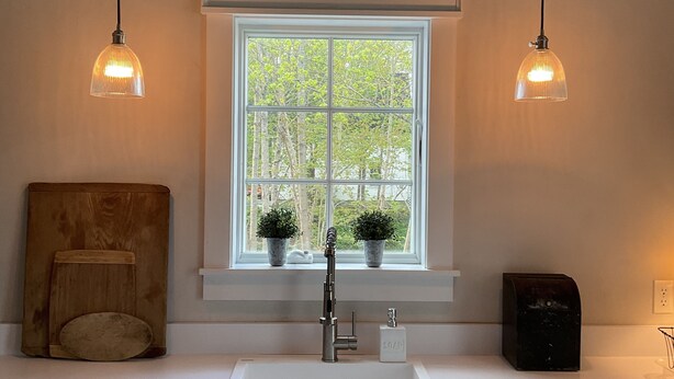 A kitchen with a window, two pendant lights, a sink, cabinets, and a toaster. - “STEP BACK IN TIME” 1880’ charmer.<br>Riverside Cottage<br> entire house (Warren)