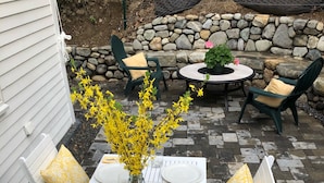An outdoor patio with a white table set for four, surrounded by white chairs with yellow cushions. - “STEP BACK IN TIME” 1880’ charmer.<br>Riverside Cottage<br> entire house (Warren)