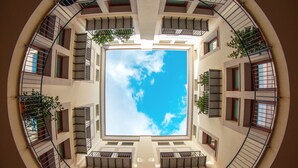 A circular view of a building with multiple balconies and windows, centered around a clear sky. - Solemar Sicilia - Galleria Maqueda (Palermo)