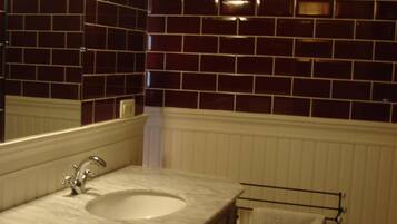 Une salle de bain avec un lavabo en marbre, un miroir et un porte-serviettes.