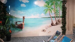 A beach scene mural with a boat, palm trees, and a hammock. - Hotel Góralski Wellness & SPA (Poronin)