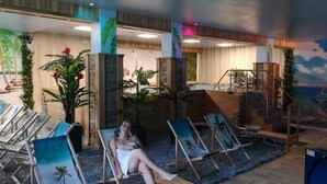 A spa area with lounge chairs, a pool, and a tropical mural. - Hotel Góralski Wellness & SPA (Poronin)