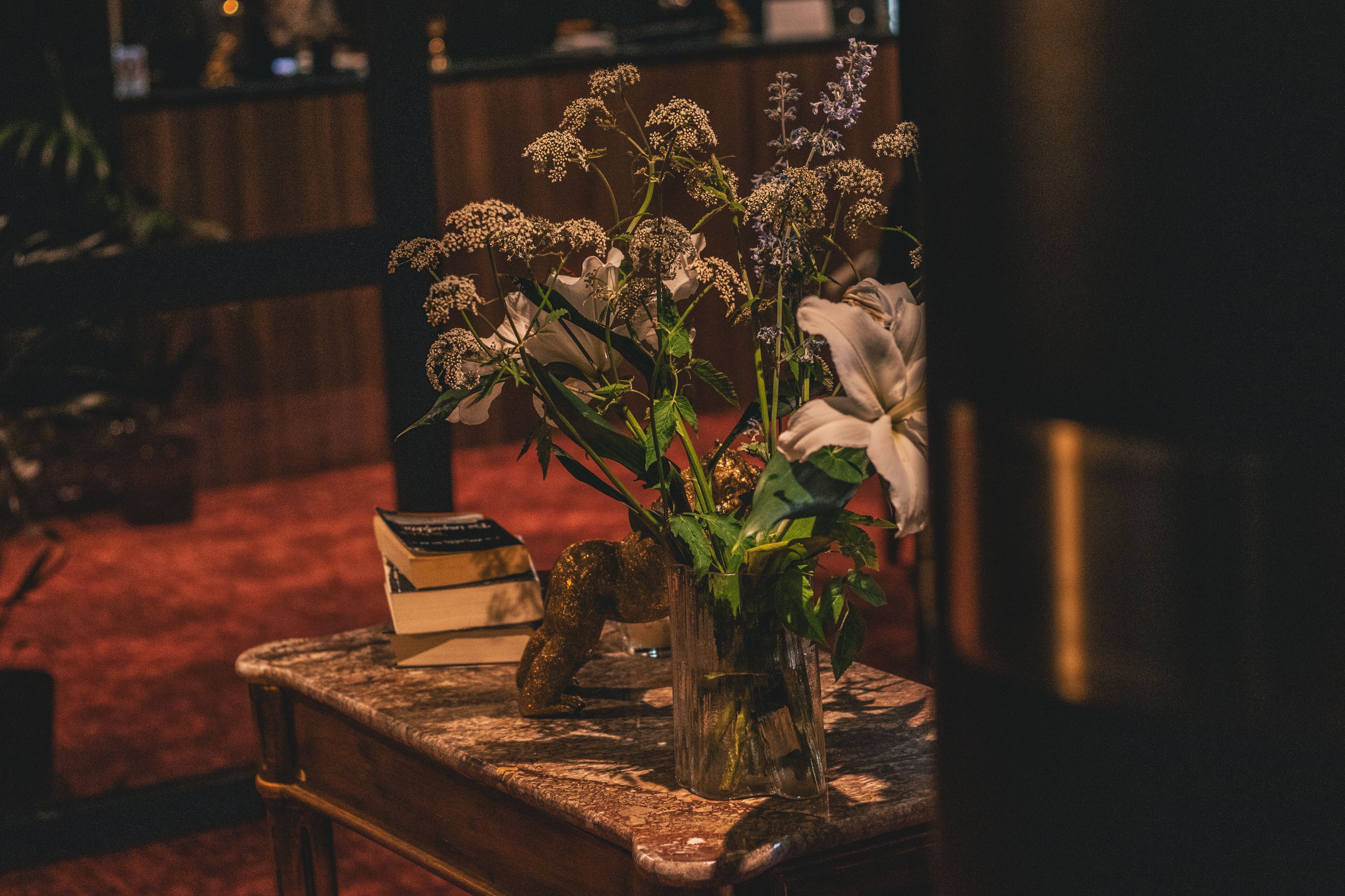 Taula amb un ram de flors, un llibre i un objecte decoratiu.