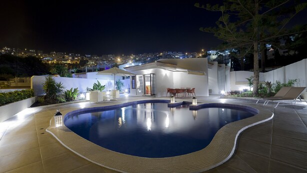 An indoor swimming pool with a view of a cityscape at night. - Haciendas Village Tenerife (Adeje)