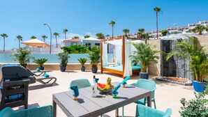 A rooftop terrace with a dining table, chairs, a grill, and potted plants. - Haciendas Village Tenerife (Adeje)