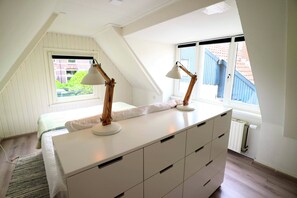 Enjoy a bright room with a sloped ceiling, skylight, and a dresser with multiple drawers.