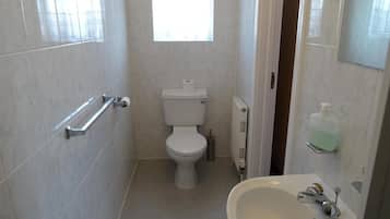 Un baño pequeño y limpio con inodoro, lavamanos y ventana.