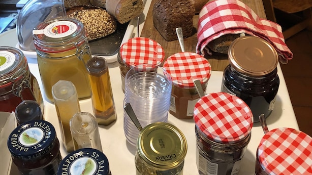 A table with various food items, including breads, jams, and honey. - Hotel zur Pfalz (Hockenheim)
