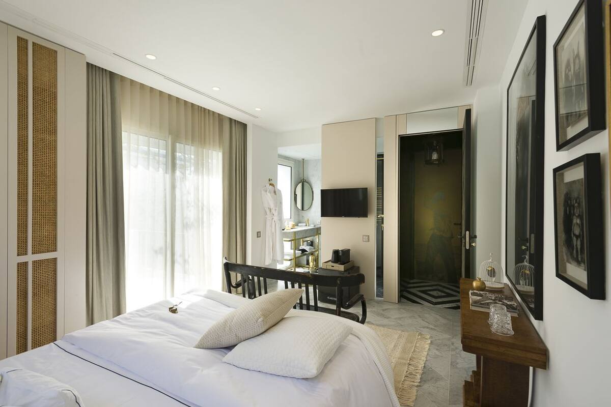 Une chambre d’hôtel moderne équipée d’un grand lit, d’un bureau, d’une télévision et d’un miroir.
